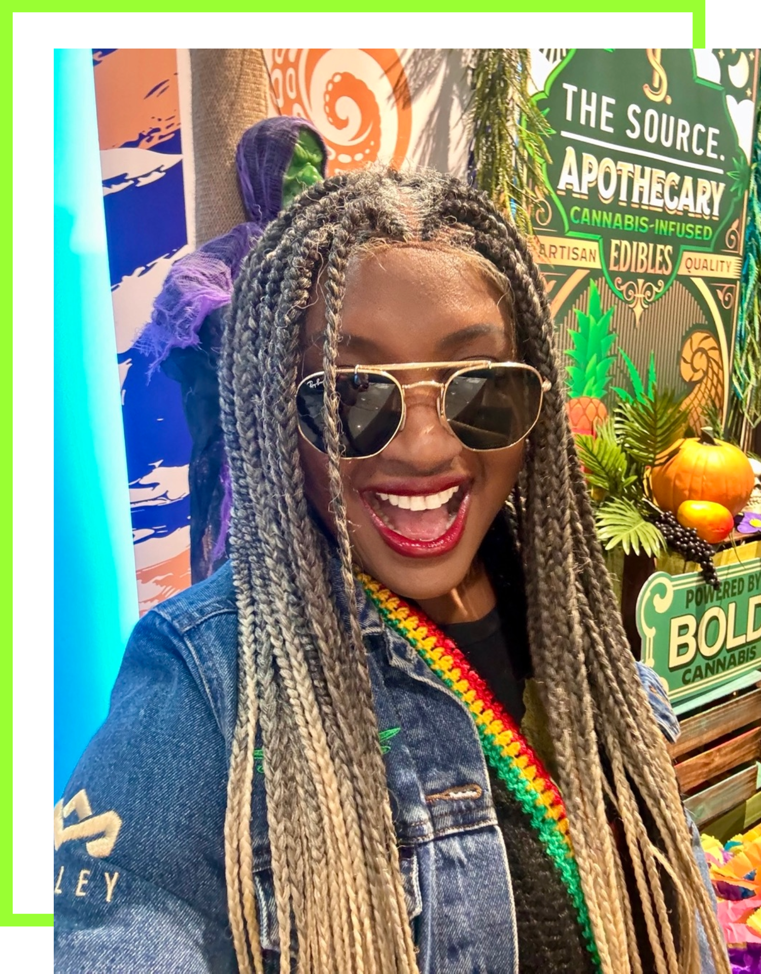 Rochelle Bradshaw, cannabis brand ambassador for The Source dispensary in Rogers, Arkansas smiling with The Source Apothecary signage and tropical decor.