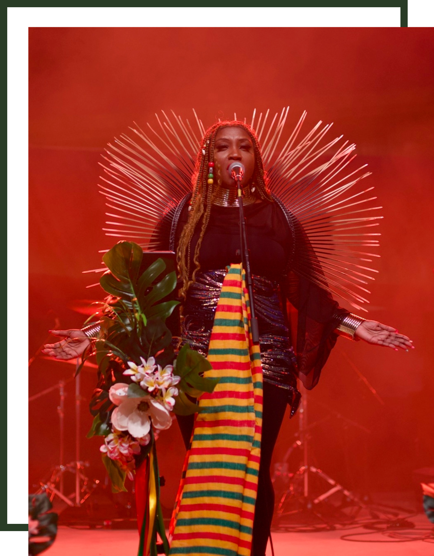 Rochelle Bradshaw wearing Rastafarian colors and performing live reggae music with dramatic red lighting at Railyard Live concert venue in Rogers, Arkansas.